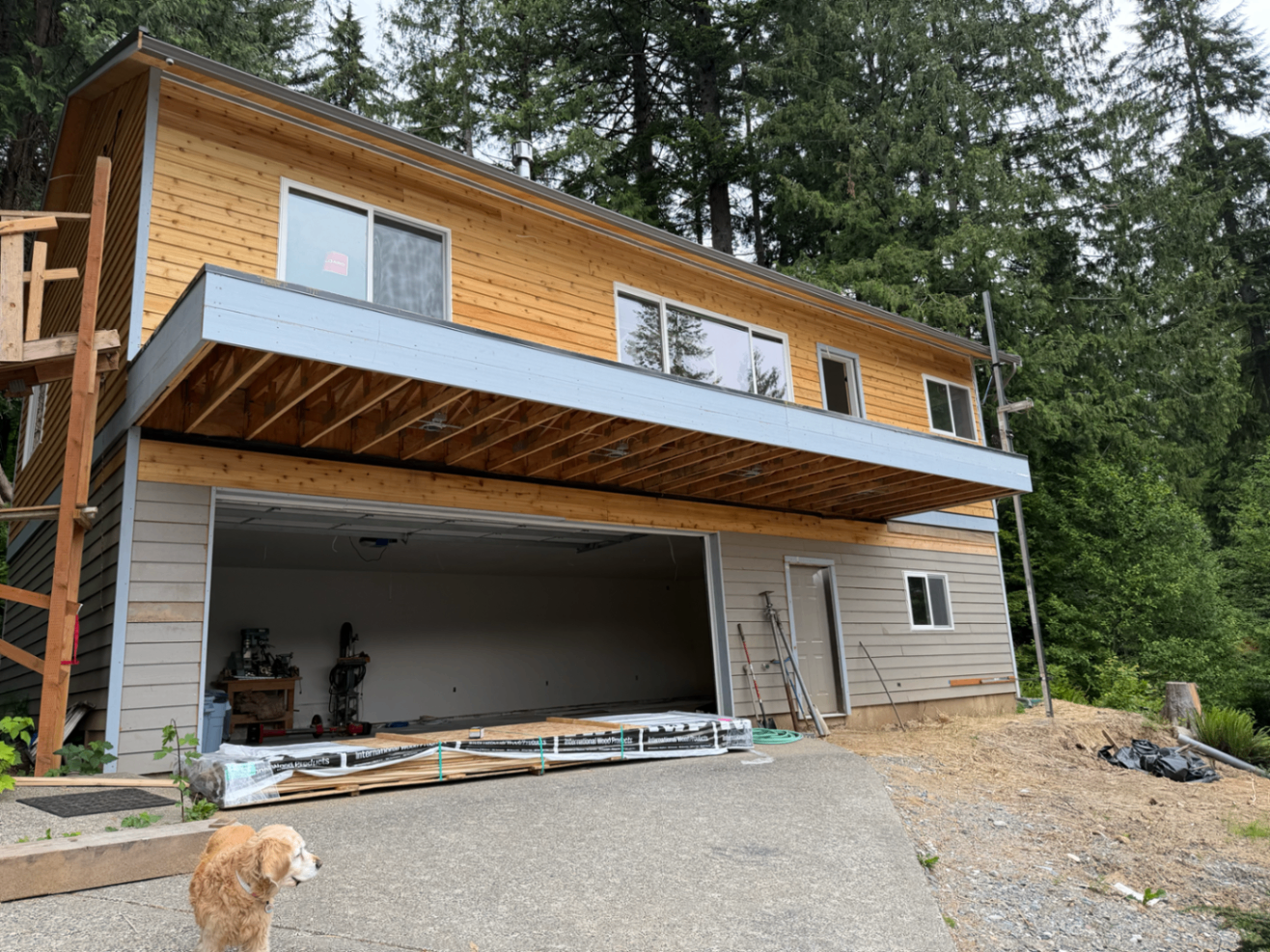 Lakefront custom home with raw, unfinished cedar exterior before painting